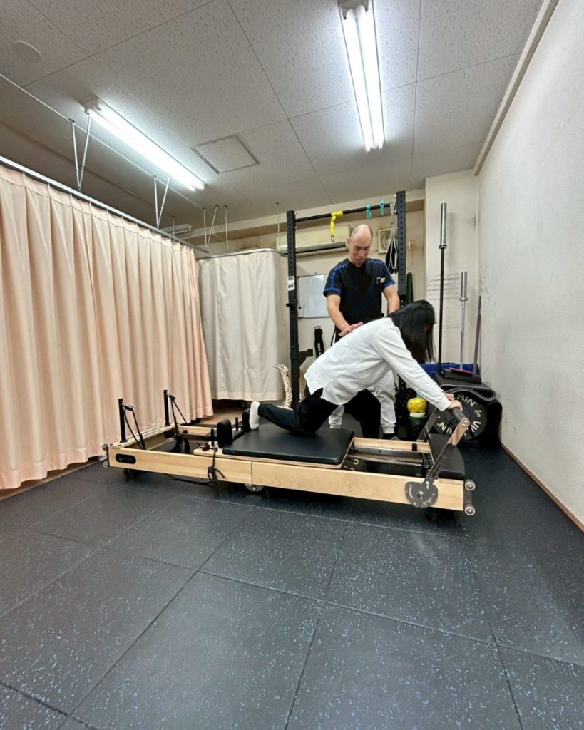 ピラティスをしている女性と指導者